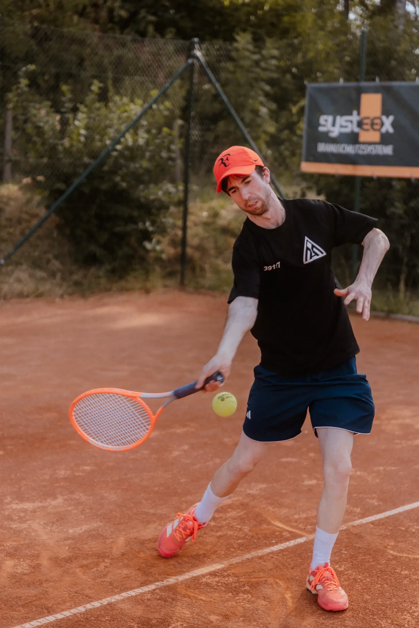 Maximilian Schneider spielt eine Vorhand auf dem Sandplatz